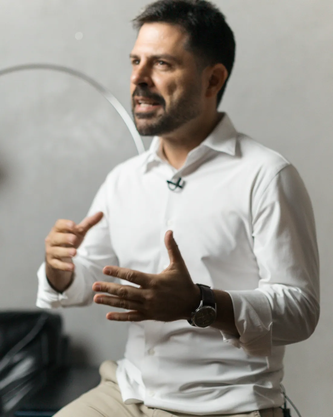 Tiago Asfora explicando, sentado, com as mãos em movimento